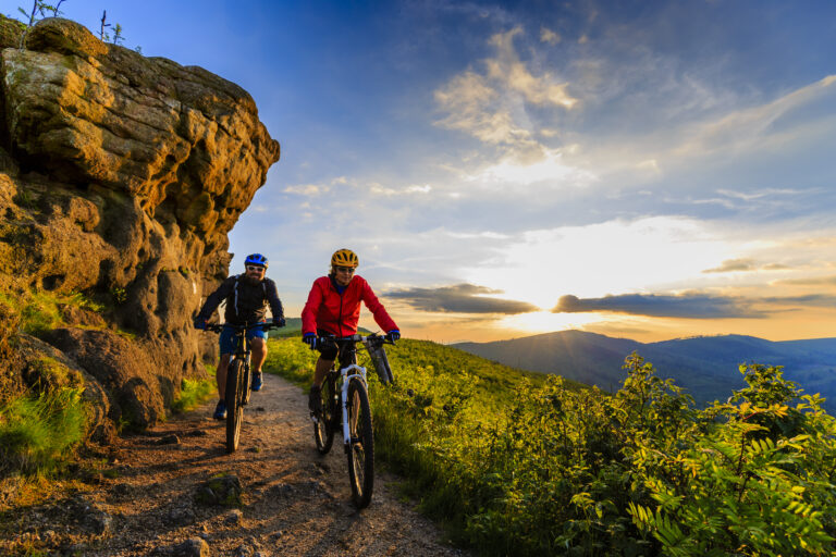 Mountain,Biking,Women,And,Man,Riding,On,Bikes,At,Sunset