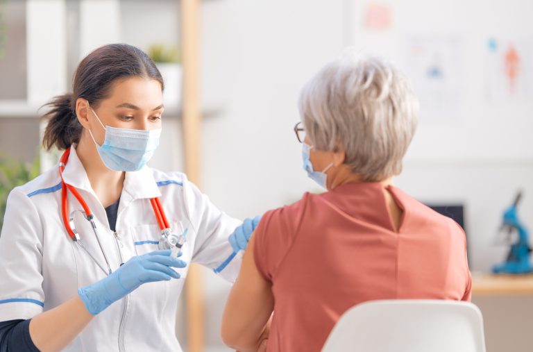 Doctor,Giving,A,Senior,Woman,A,Vaccination.,Virus,Protection.,Covid-2019.