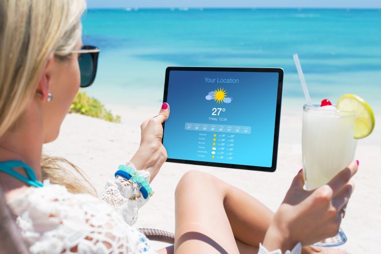 Woman,Viewing,Weather,Forecast,On,Tablet,While,Relaxing,On,The
