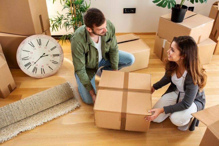 Young,Couple,Holding,A,Box,For,Unpacking,While,Talking