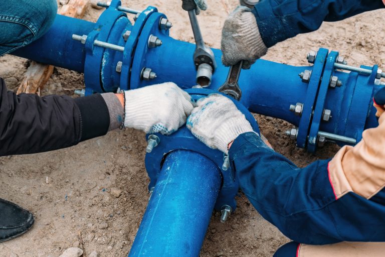 Workers,Installing,Water,Supply,Pipeline,System,,Close,Up