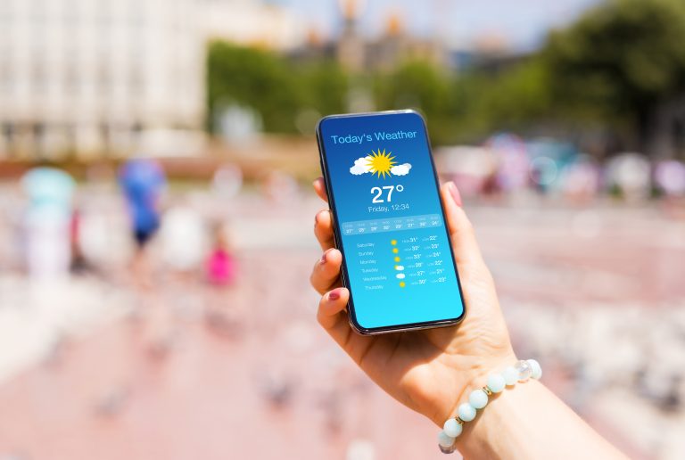 Woman,Outside,In,City,Checking,Weather,Forecast,On,Her,Mobile