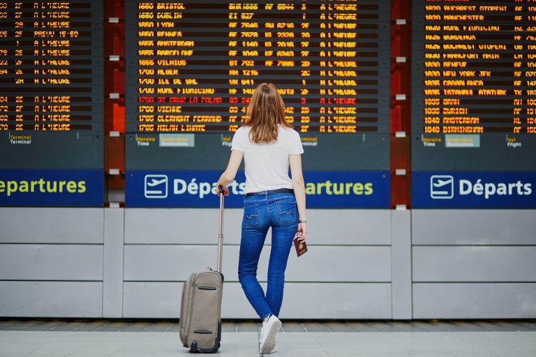 Young,Woman,In,International,Airport,With,Luggage,And,Passport,Near
