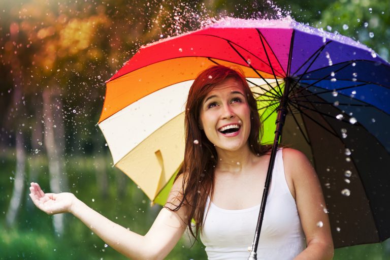 Surprised,Woman,With,Umbrella,During,Summer,Rain