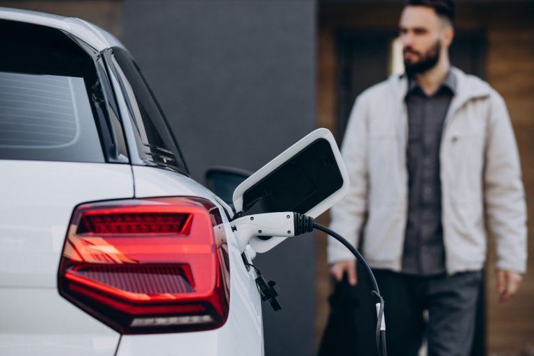 Man,Charging,Electric,Car,By,The,House
