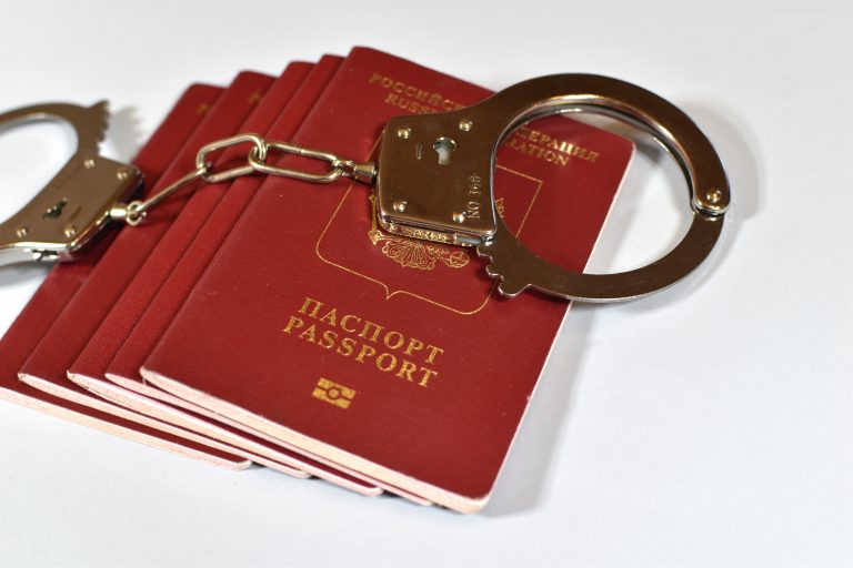 Russian,Passport,And,Handcuffs,On,A,White,Background.,Prohibition,Of