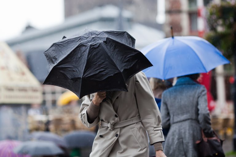 People,Walking,With,Umbrellas,In,The,Rainy,City