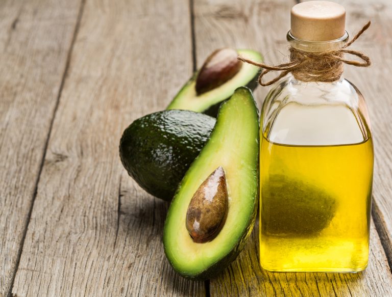 Fresh,Sliced,Avocado,And,Bottle,Of,Oil,On,Wooden,Background,