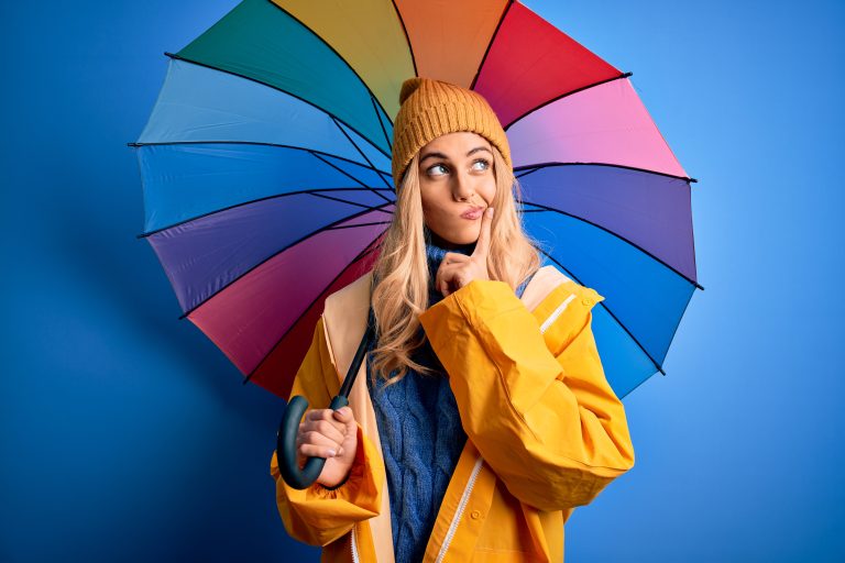 Young,Beautiful,Blonde,Woman,Wearing,Raincoat,For,Rainy,Weather,Holding