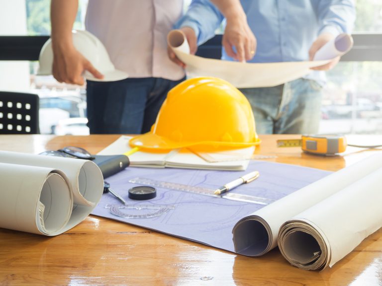 Architect,Concept,,Architects,Working,With,Blueprints,In,The,Office