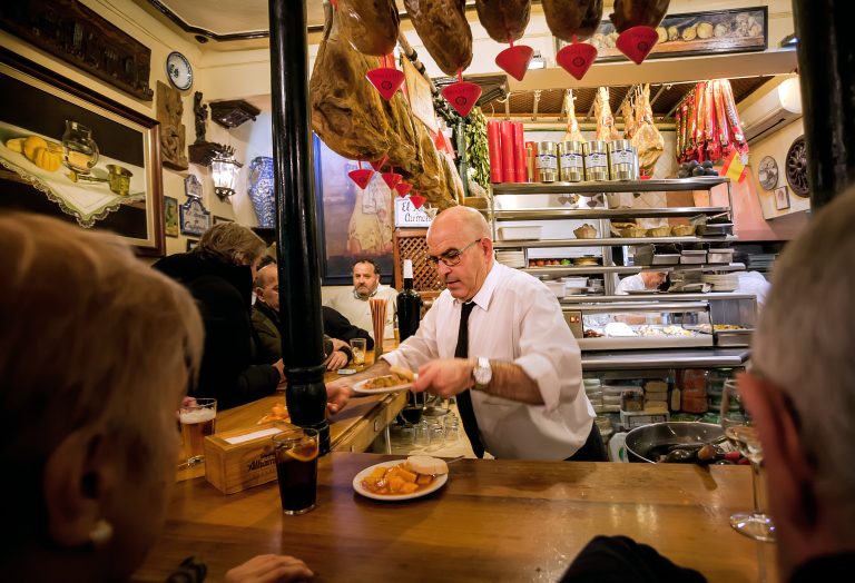 Granada,,Spain:,Elderly,Barman,Is,Serving,Ready-made,Meals,For,Drinking