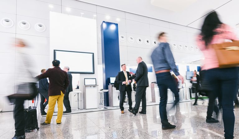 Crowd,Of,Business,People,At,A,Trade,Show,Booth