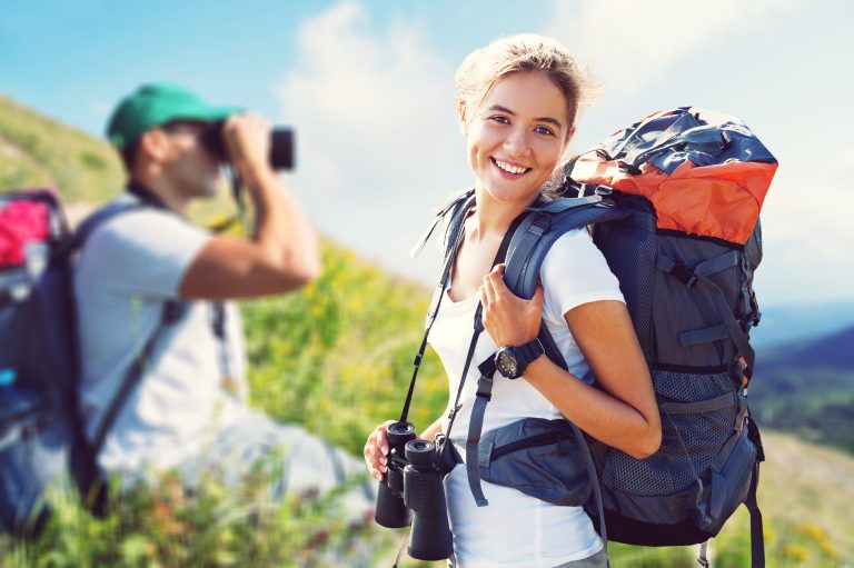 A,Group,Of,Tourists,With,Backpacks,Are,Walking,Along,The