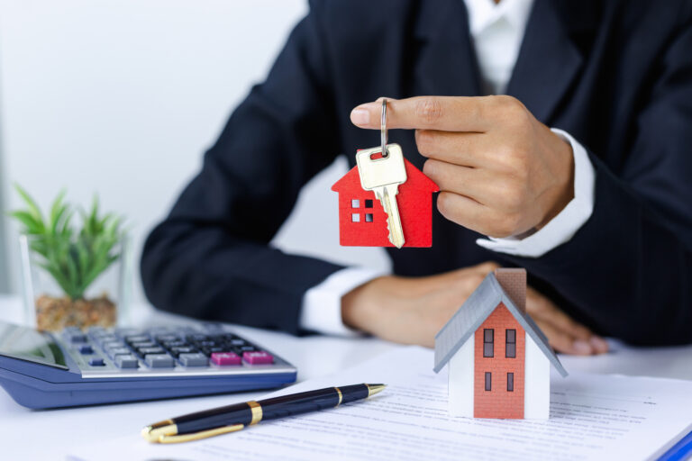 Real,Estate,Agent,Holding,A,Red,House,Key,Ring,Real