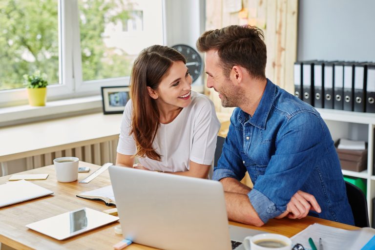 Happy,Couple,Working,Together,At,Office,Looking,At,Each,Other