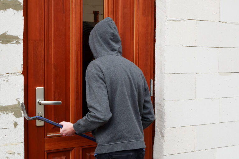 Robber,In,Hood,Trying,Open,Door,With,Crowbar,And,Looking