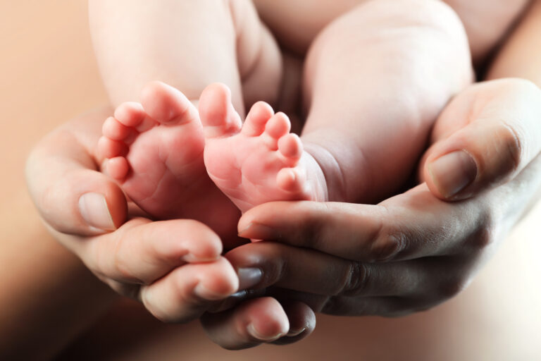 Baby's,Foot,In,Mother,Hands.