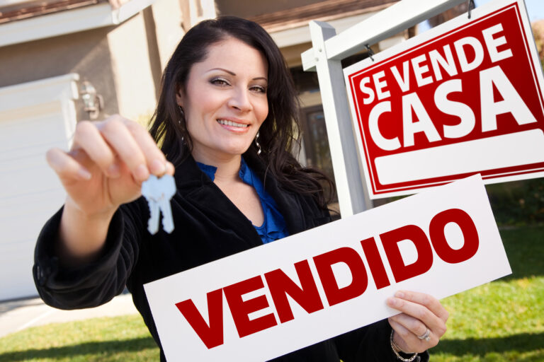 Happy,Attractive,Hispanic,Woman,Holding,Vendido,Real,Estate,Sign,And