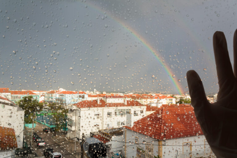 Women,Hand,With,Medical,Glove,At,Rainy,Window,With,Rainbow