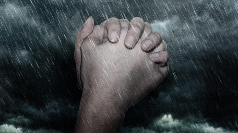 Composite,Of,Hands,In,Prayer,And,Rainfall,And,Storm,Clouds.