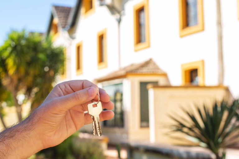 A,Man's,Hand,Holds,The,Keys,To,The,Apartment,Against