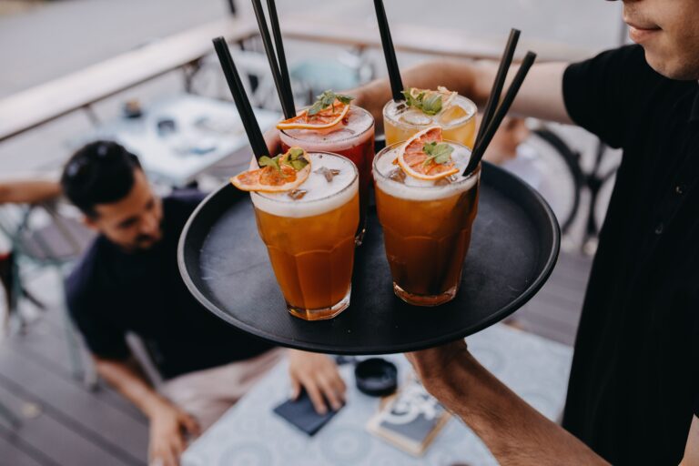 Waiter,Serving,Summer,Cocktails,To,A,Group,Of,Friends.