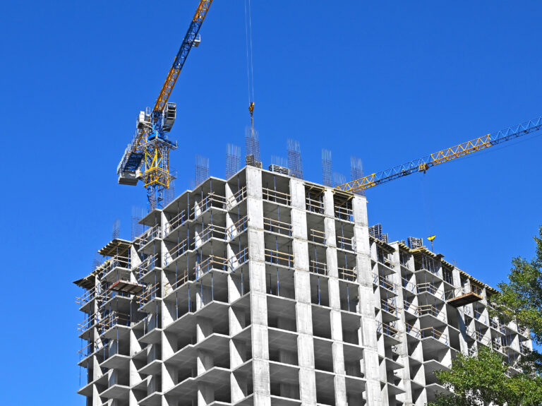 Crane,And,Building,Under,Construction,Against,Blue,Sky