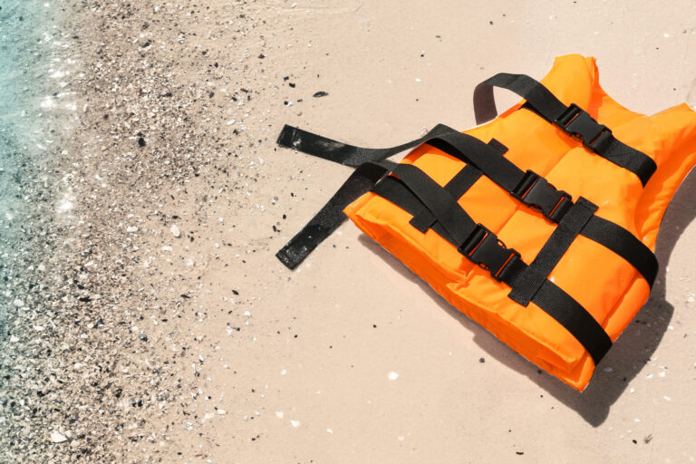 Orange,Life,Jacket,On,Sand,Near,Sea,,Above,View.,Emergency