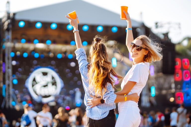 Two,Young,Woman,Drinking,Beer,And,Having,Fun,At,Beach