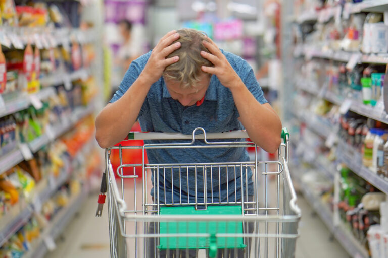 Upset,Man,In,A,Supermarket,With,An,Empty,Shopping,Trolley.