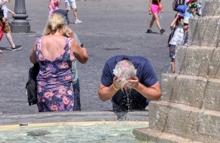 Tourist,Refreshes,His,Head,With,Water,From,A,Fountain,On