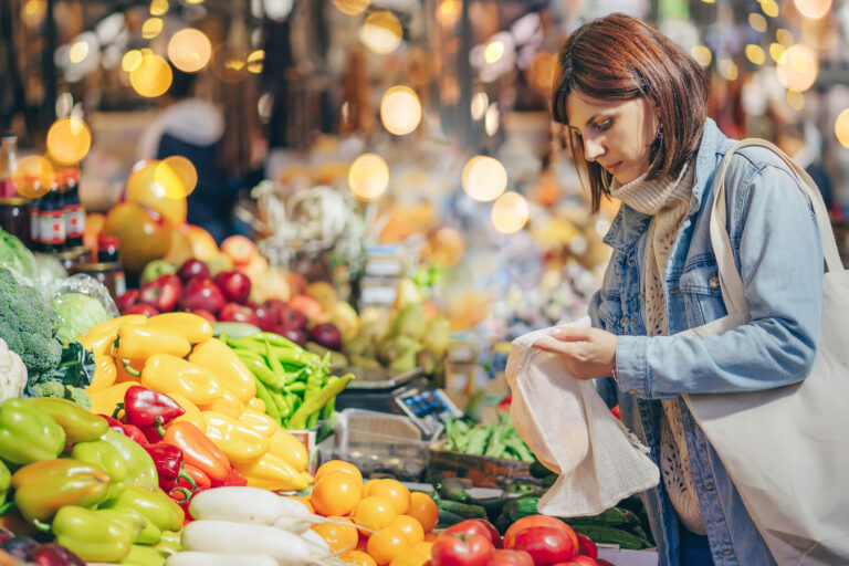 Young,Woman,Puts,Fruits,And,Vegetables,In,Cotton,Produce,Bag