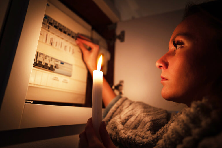 Woman,Checking,Fuse,Box,At,Home,During,Power,Outage,Or