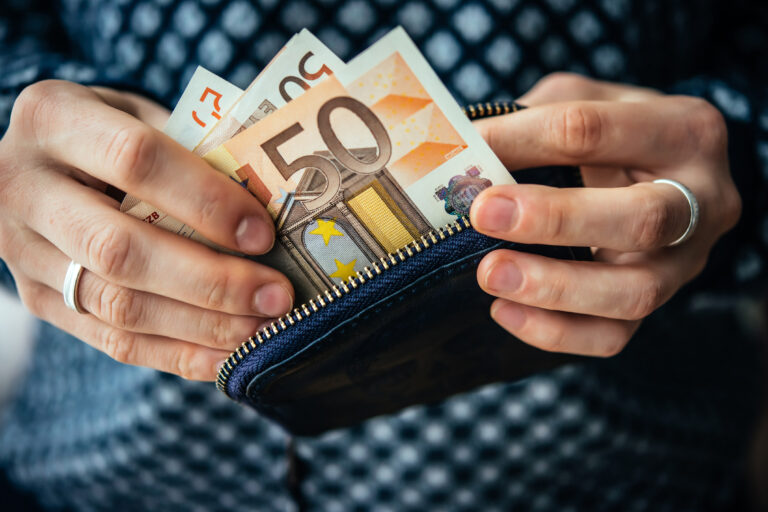 Hands,Holding,Euro,Bills,And,Small,Money,Pouch