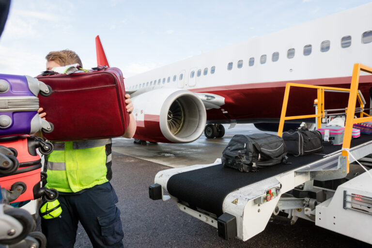 Ground,Member,Stacking,Bags,On,Trailer,At,Runway