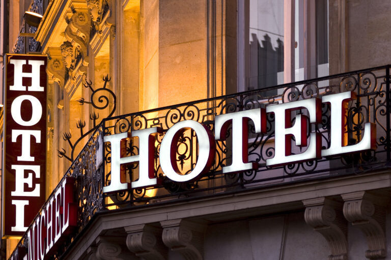 Illuminated,Parisian,Hotel,Sign,Taken,At,Dusk