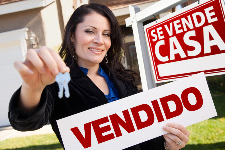 Happy,Attractive,Hispanic,Woman,Holding,Vendido,Real,Estate,Sign,And