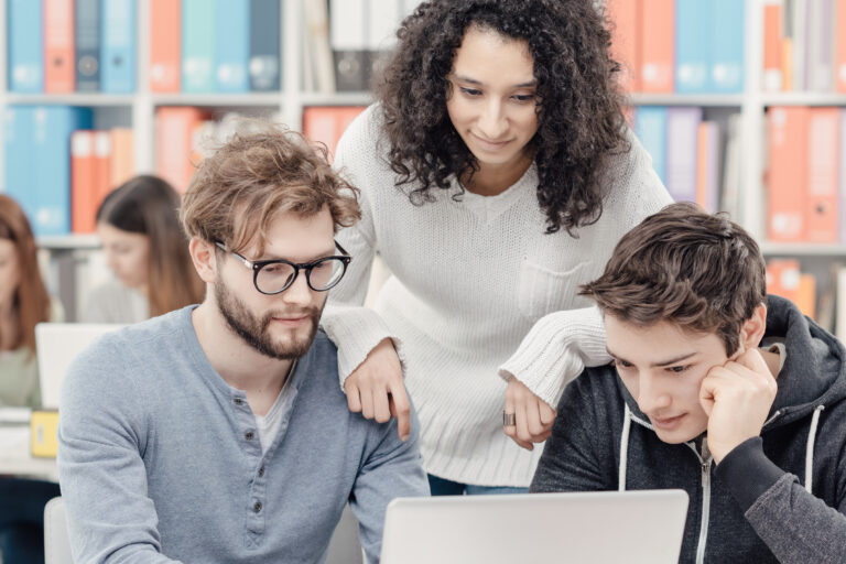 Group,Of,Students,Connecting,Together,With,A,Laptop,And,Smiling,