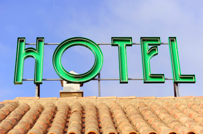 Hotel,Sign,Placed,On,The,Roof,,Bright,Green,Neon