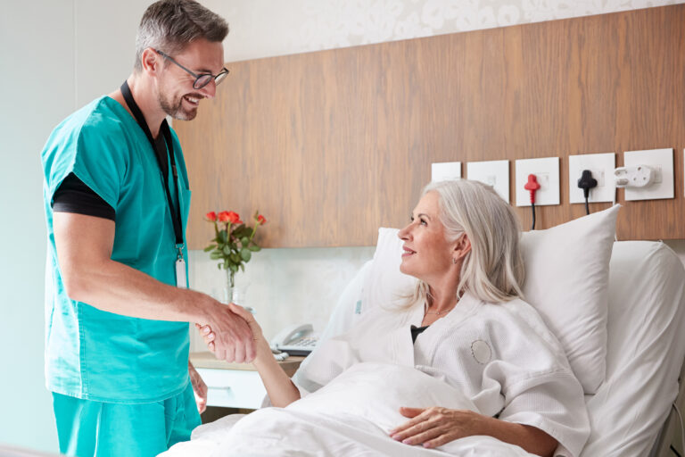 Surgeon,Visiting,And,Shaking,Hands,With,Mature,Female,Patient,In
