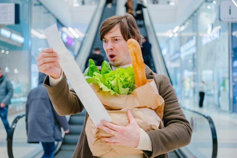 Man,In,A,Coat,Holds,A,Paper,Check,And,A