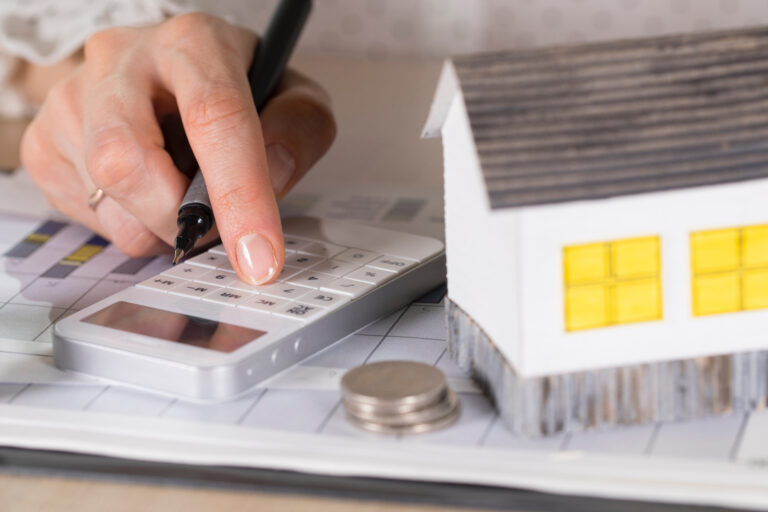 Young,Woman,Makes,Some,Calculations.,Small,Paper,House,,Coins,,Car