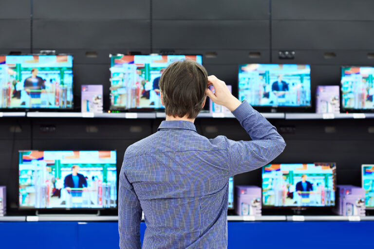 Man,Looks,At,Lcd,Tvs,In,Supermarket