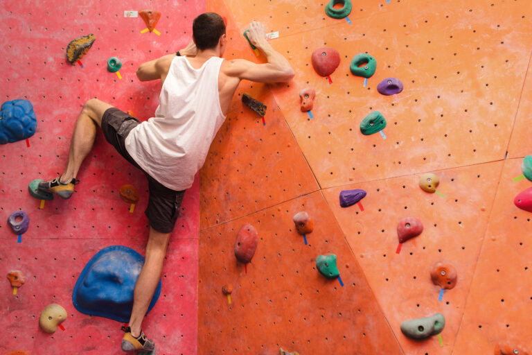 Man,Climber,On,Artificial,Climbing,Wall,In,Bouldering,Gym