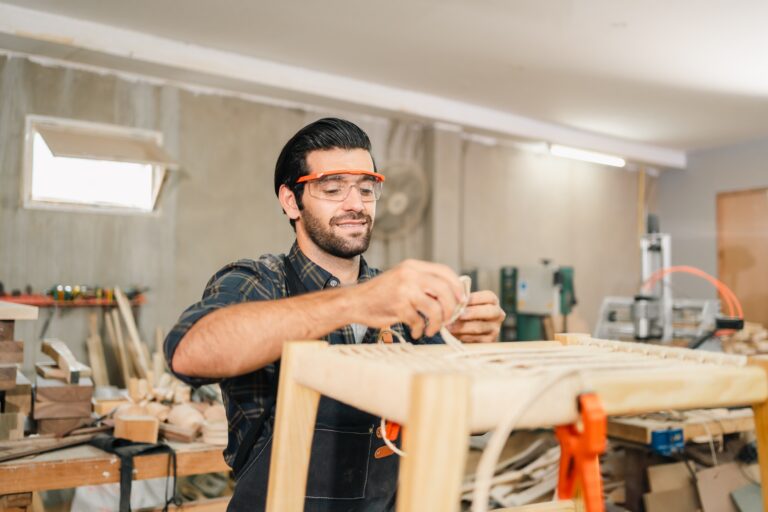 Carpenter,Working,With,Electric,Planer,On,Wooden,Plank,In,Workshop.