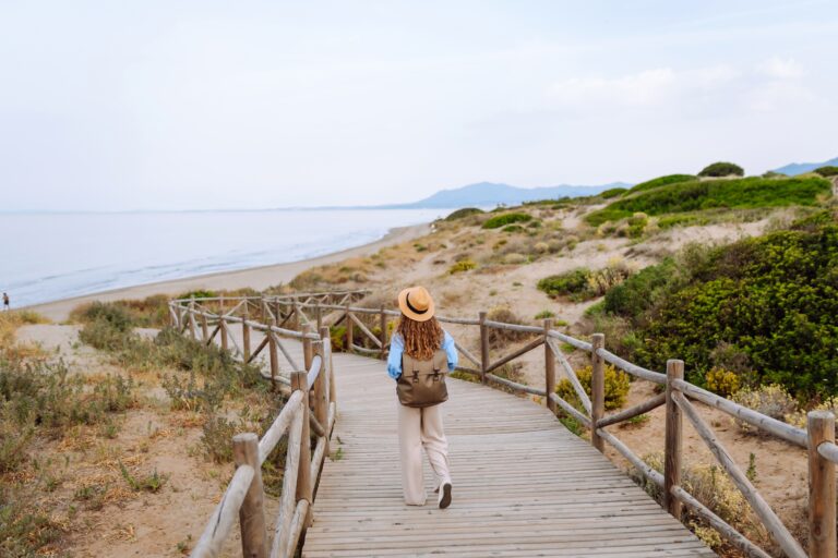 A,Happy,Young,Woman,Stands,On,A,Wooden,Boardwalk,Near