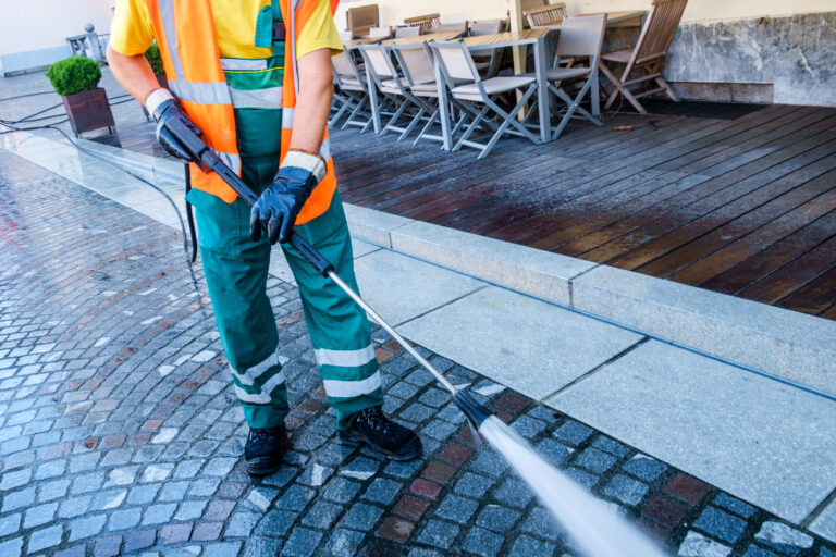 Worker,Cleaning,The,Cobbled,Street,In,Ljubljana,,Slovenia.