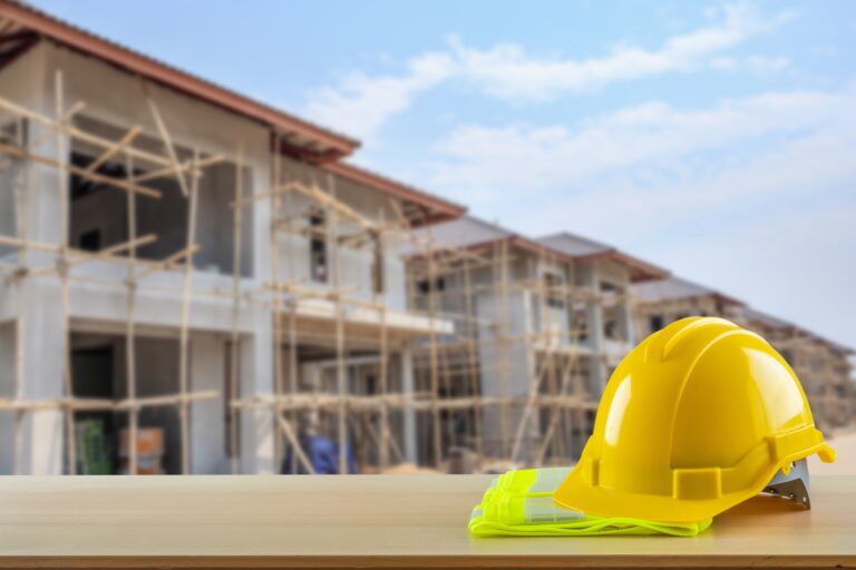 Yellow,Safety,Construction,Helmet,On,Wood,Table,With,Construction,Site