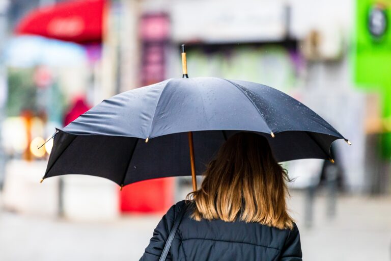People,With,Umbrella,On,The,Street,On,A,Rainy,Day