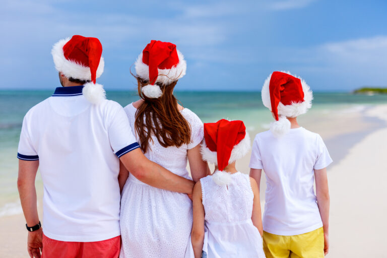 Back,View,Of,Beautiful,Family,Wearing,Red,Santa,Hats,At